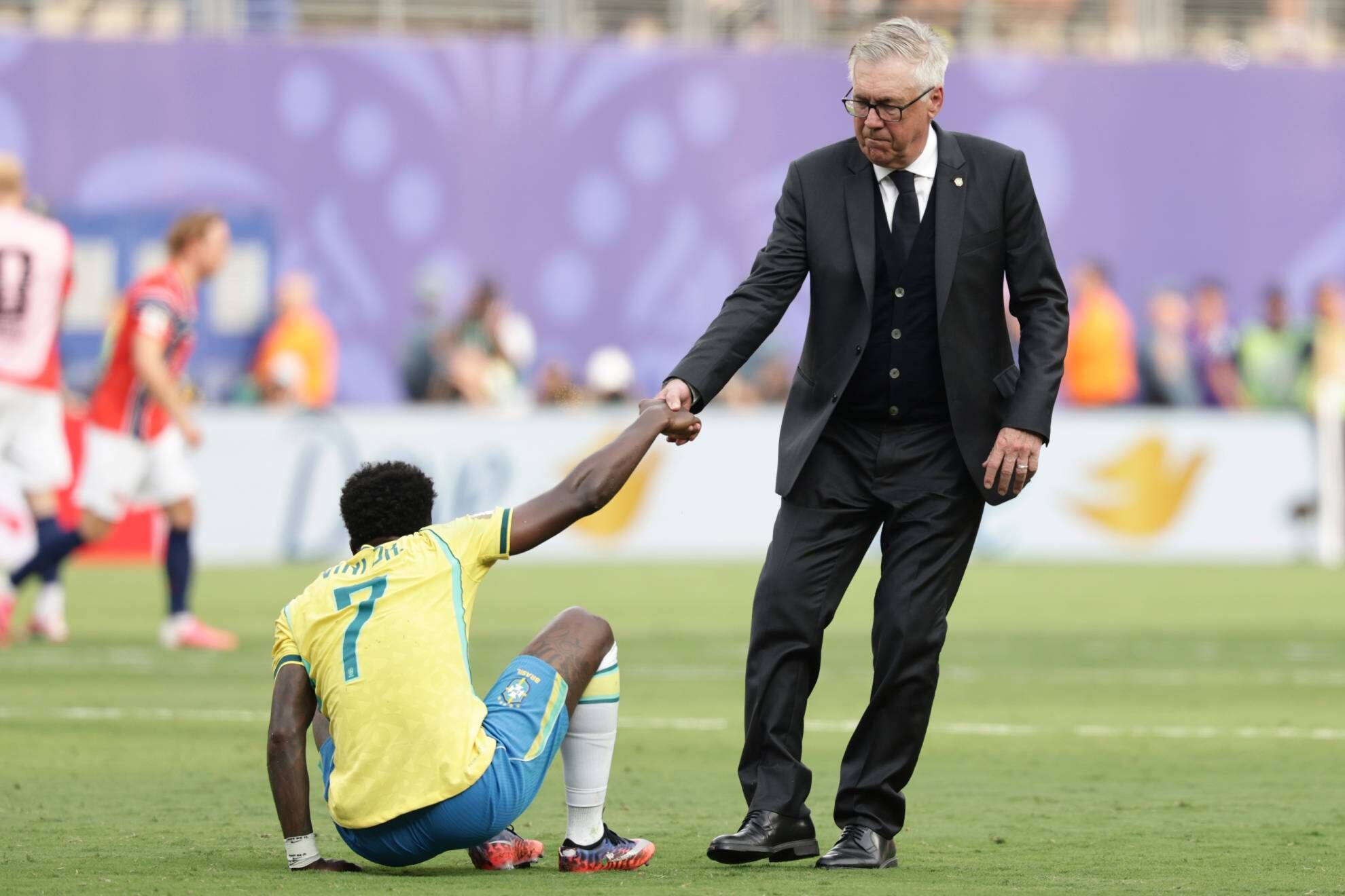El seleccionador principal de Brasil, Carlo Ancelotti, ayuda al Vinicius Junior (7) de Brasil a levantarse durante el partido de octavos de final del Mundial entre Brasil y Noruega en East Rutherford, Nueva Jersey