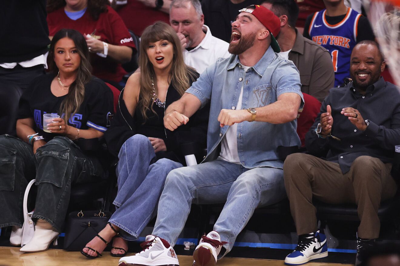Taylor Swift and Travis Kelce sit in the front row at the arena...