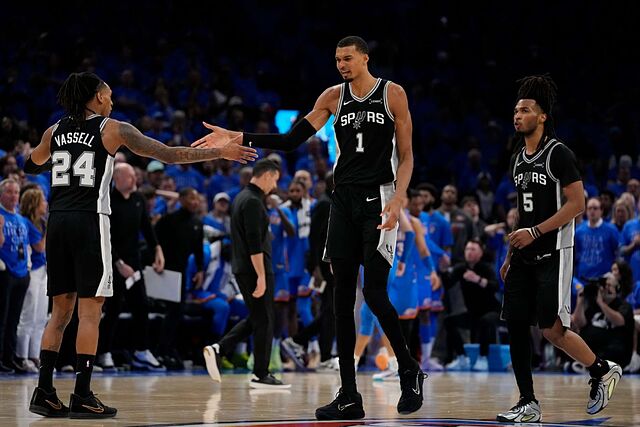 El alero de los San Antonio Spurs, Victor Wembanyama (1), celebra junto al escolta Devin Vassell (24) y al escolta Stephon Castle (5) durante la serie de playoffs de la NBA contra los Oklahoma City Thunder